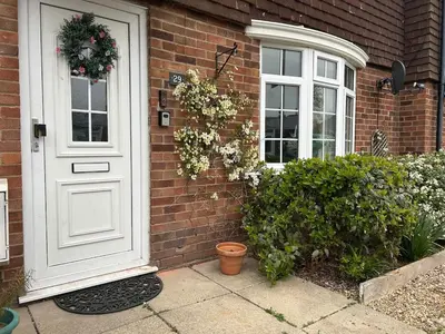 a brick house with a white door and a window at Cosy island home near beach in West Mersea