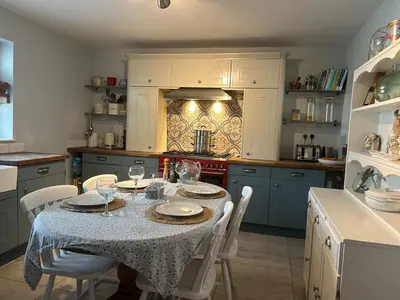 a kitchen with a table with plates and wine glasses at Cosy island home near beach in West Mersea