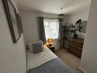 a small bedroom with a bed and a window at Cosy island home near beach in West Mersea