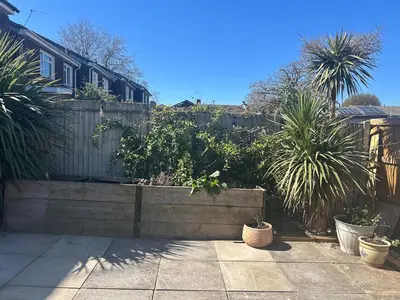 a backyard with a fence and some plants at Cosy island home near beach in West Mersea