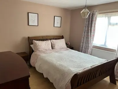 a bedroom with a large bed and a window at Cosy island home near beach in West Mersea