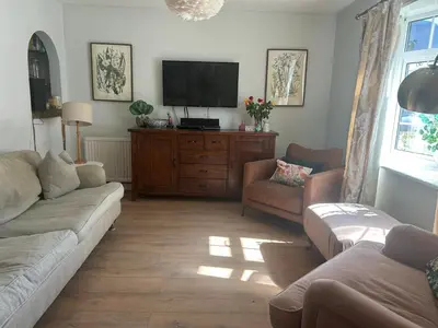 a living room with a couch and a flat screen tv at Cosy island home near beach in West Mersea
