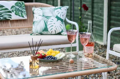 two glasses of wine and a bowl of fruit on a table at Stylish 2 Bedroom Property in Bury Saint Edmunds