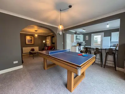 a living room with a ping pong table in it at Seafront Beach House in Southend-on-Sea
