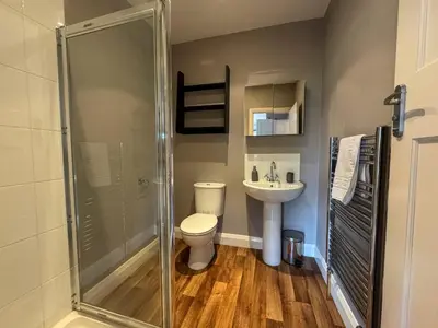 a bathroom with a shower and a toilet and a sink at Seafront Beach House in Southend-on-Sea