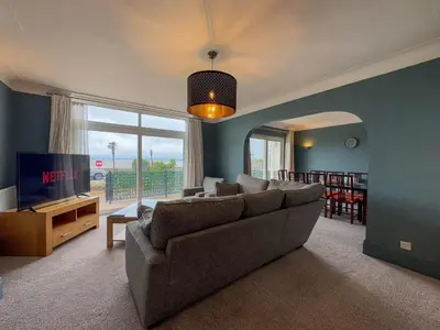 a living room with a couch and a television at Seafront Beach House in Southend-on-Sea