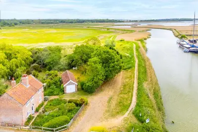 an aerial view of a house next to a river at Stunning estuary views - Riverside Cottage in Snape