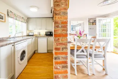 a kitchen and dining room with a table and chairs at Stunning estuary views - Riverside Cottage in Snape