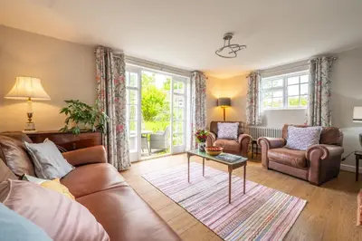 a living room with a couch and a table at Stunning estuary views - Riverside Cottage in Snape