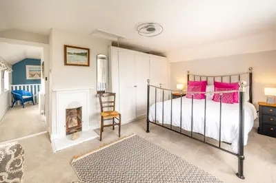a bedroom with a bed and a fireplace at Stunning estuary views - Riverside Cottage in Snape