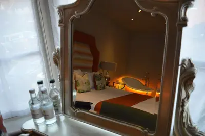 a reflection of a bedroom with a bed in a mirror at Long Melford Swan in Long Melford