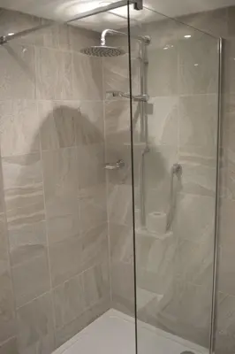 a shower with a glass door in a bathroom at Long Melford Swan in Long Melford