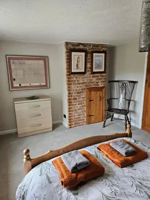 a bedroom with a bed with two towels on it at 2 Church Path in Earsham