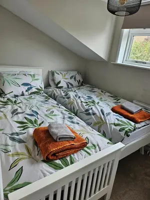 a bedroom with two beds with towels on them at 2 Church Path in Earsham