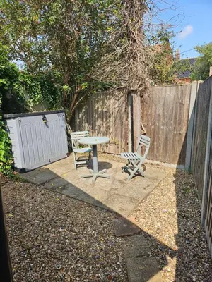 a patio with a table and two chairs and a fence at 2 Church Path in Earsham