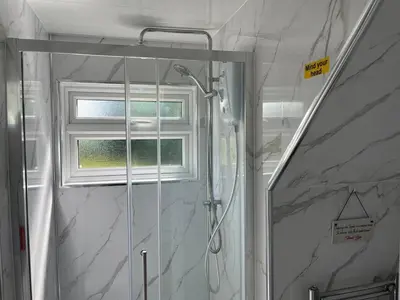 a shower in a bathroom with a window at Rubys cartlodge in Stambourne