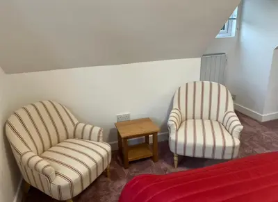 two chairs and a table in a bedroom at Rubys cartlodge in Stambourne