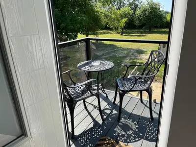 a patio with two chairs and a table on a porch at Rubys cartlodge in Stambourne