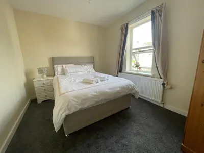 a small bedroom with a bed and a window at Ouse River Quay Hill Lodge in Littleport