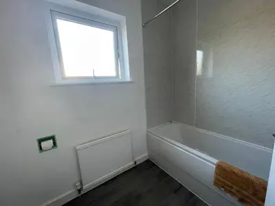 a white bathroom with a tub and a window at Ouse River Quay Hill Lodge in Littleport