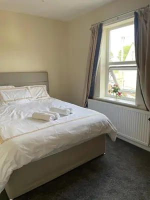 a bedroom with a white bed with a window at Ouse River Quay Hill Lodge in Littleport
