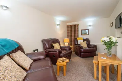 a living room with a couch and two chairs at Pebbles, King St - Aldeburgh Coastal Cottages in Aldeburgh