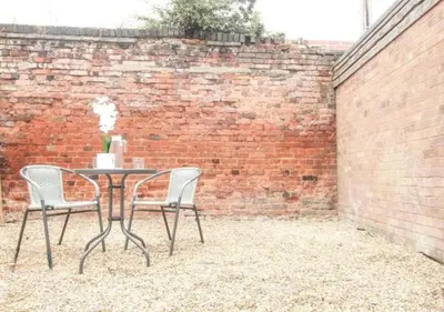 a table and chairs in front of a brick wall at Pet Friendly 2-Bed Home Near Marina & Town - Free Parking in Ipswich