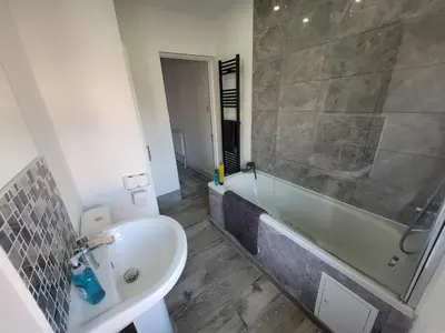a bathroom with a tub and a sink and a bath tub at Pet Friendly 2-Bed Home Near Marina & Town - Free Parking in Ipswich
