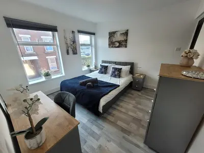 a bedroom with a bed and a table in it at Pet Friendly 2-Bed Home Near Marina & Town - Free Parking in Ipswich