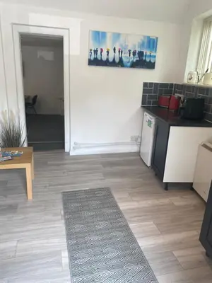 a living room with a kitchen and a table at The Meadows in Bishops Stortford