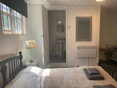 a bedroom with a bed with a sink and a mirror at The Meadows in Bishops Stortford