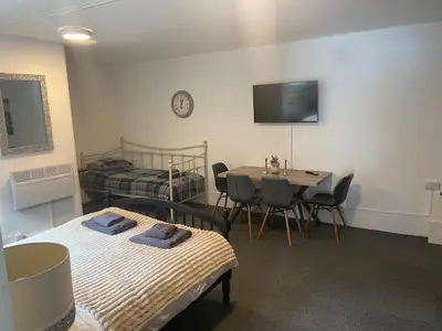 a room with a bed and a table with chairs at The Meadows in Bishops Stortford