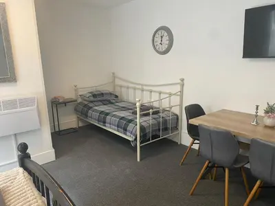 a bedroom with a bed and a table with chairs at The Meadows in Bishops Stortford