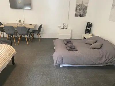 a bedroom with a bed and a table and chairs at The Meadows in Bishops Stortford