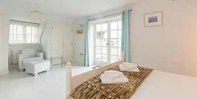 a bedroom with a bed with two pillows on it at 5 The Sanctuary, Thorpeness - Aldeburgh Coastal Cottages in Thorpeness