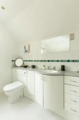 a white bathroom with a toilet and a sink at 5 The Sanctuary, Thorpeness - Aldeburgh Coastal Cottages in Thorpeness
