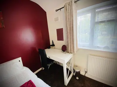 a bedroom with a desk and a bed and a window at Modern-PetFriendly-privateGarden-Family-20MinToLDN in Stevenage