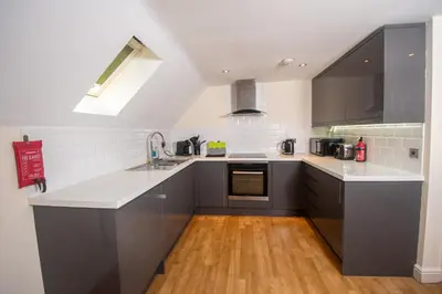 a kitchen with gray cabinets and a wooden floor at Newly Renovated Sanctuary for 4 in Tacket Street, Ipswich in Ipswich