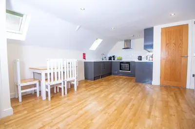 a kitchen and dining room with a wooden floor and a table at Newly Renovated Sanctuary for 4 in Tacket Street, Ipswich in Ipswich