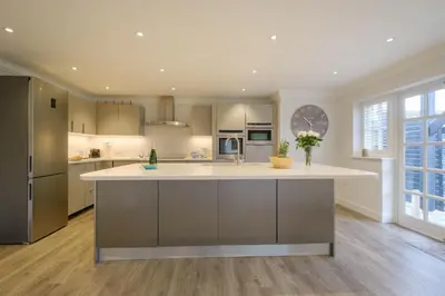 a large kitchen with a large island in the middle at 8 Sanctuary, Very close to Thorpeness Meare and the beach - Aldeburgh Coastal Cottages in Thorpeness