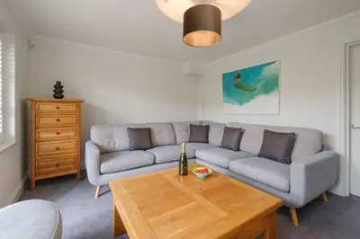 a living room with a couch and a table at 8 Sanctuary, Very close to Thorpeness Meare and the beach - Aldeburgh Coastal Cottages in Thorpeness