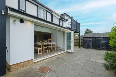 an external view of a house with a patio at 8 Sanctuary, Very close to Thorpeness Meare and the beach - Aldeburgh Coastal Cottages in Thorpeness