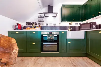 a green kitchen with green cabinets and an oven at Fairytale Staycation - Near London by Damask Homes in Stapleford Tawney
