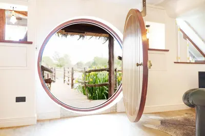 a round mirror in a room with a window at Fairytale Staycation - Near London by Damask Homes in Stapleford Tawney