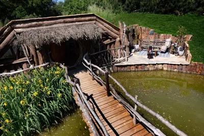 a wooden house with a pond and a wooden deck at Fairytale Staycation - Near London by Damask Homes in Stapleford Tawney