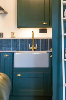 a kitchen with blue cabinets and a sink at Fairytale Staycation - Near London by Damask Homes in Stapleford Tawney