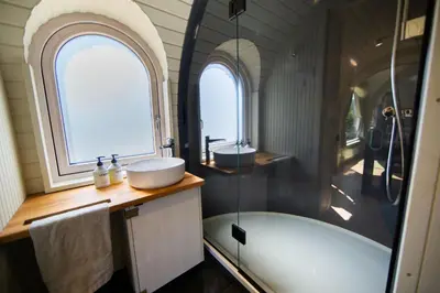 a bathroom with a tub and a sink and two windows at The Lodges - Waresley Park Estate