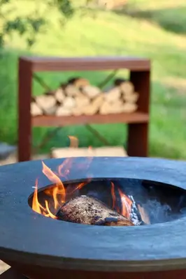 a fire pit with a piece of food in it at The Lodges - Waresley Park Estate