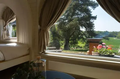 a bedroom with a window with a view of a tree at The Lodges - Waresley Park Estate