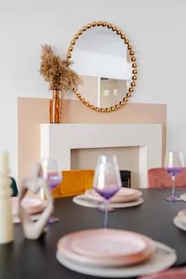 a table with plates and glasses and a mirror at Stylish 5Bedroom Getaway in Quiet Mildenhall Area in Mildenhall